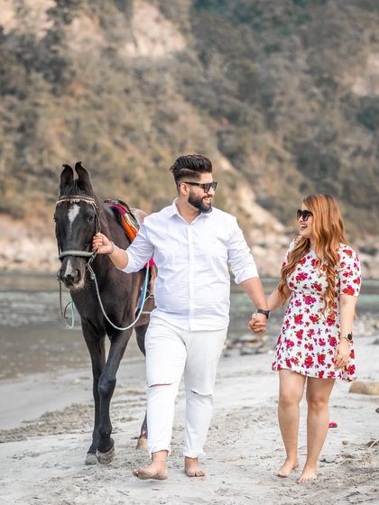 A unique pre-wedding shot featuring the couple with a horse on the beach, adding a rustic and charming element to their photoshoot.