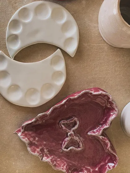 Imperfections add character. Here, a student's leaf-shaped dish and moon-phase palettes celebrate the beauty of the handmade.