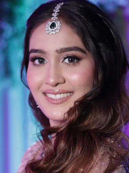 The lighting here highlights the beautiful glow on her skin. This reception look is all about enhancing her natural beauty with clean details and a radiant finish.