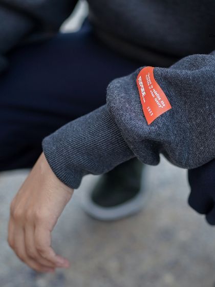 The Flypside hoodie features a branded orange tag on the sleeve, a small detail that signifies quality and authenticity.
