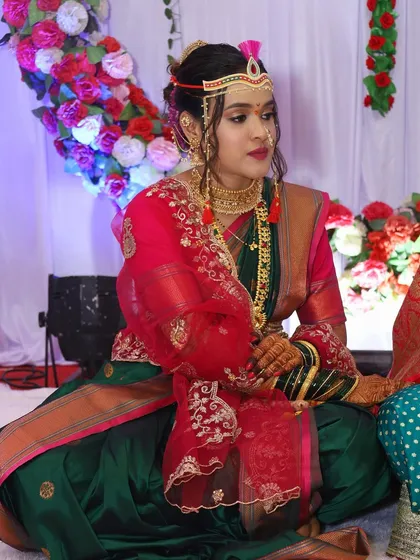 A candid shot of the bride during her wedding rituals. Her makeup is designed to be long-lasting and photogenic, ensuring she looks flawless throughout the day.