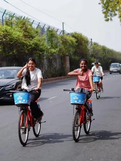 Smiles for miles. Two riders share a happy moment while cycling through the city. The simple joy of riding with a friend is what our tours are all about.