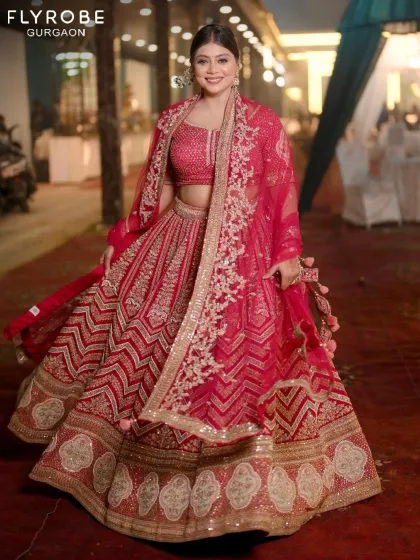 Twirl into your new beginning with this magnificent red bridal lehenga. The chevron-patterned skirt and heavily embroidered dupatta create a look that's both grand and graceful.