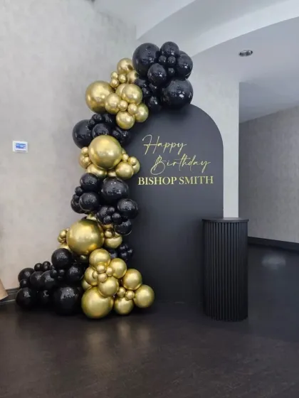 An elegant and minimalist birthday backdrop perfect for adult celebrations. This design uses a sophisticated black and gold color scheme, with a custom "Happy Birthday" message on a clean, arched backdrop, accented by a chic balloon garland.