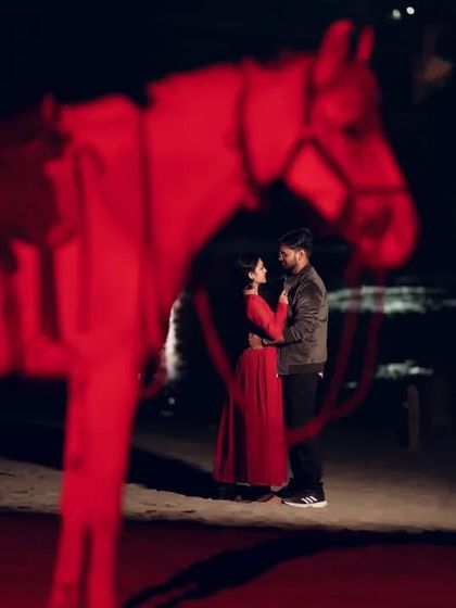 A creative and dramatic night shot using a red-lit horse prop. This adds a unique and artistic element to the couple's pre-wedding photography.