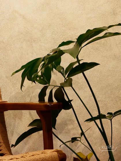 The armrest detail of the rope-woven easy chair, showing how the teak frame provides a solid anchor for the textured seating.