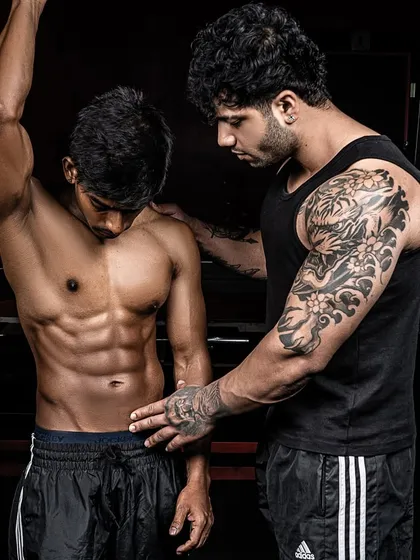 My coaching is hands-on. Here, I'm making fine-tune adjustments to a client's posing to ensure every muscle fiber shows on stage. This level of detail is what separates the winners from the rest.