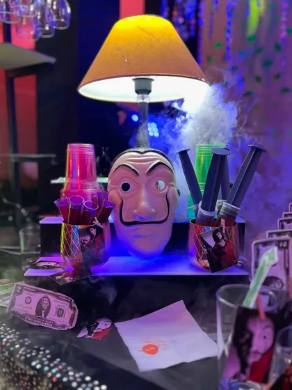 Your bar should match your vibe, no matter how unique. For this event, I designed a complete Money Heist themed bar, complete with Dali masks, custom cocktail names, and even drink "syringes" to fit the theme.