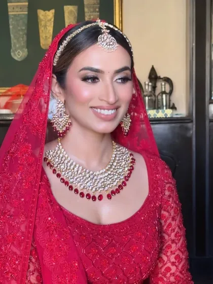 A beautiful portrait of our bride Saakshi, showcasing her complete look with the sheer red dupatta and timeless makeup.