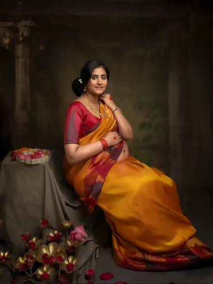 A serene and elegant portrait. The way she is seated, surrounded by flowers, gives this image a classic, painterly quality.