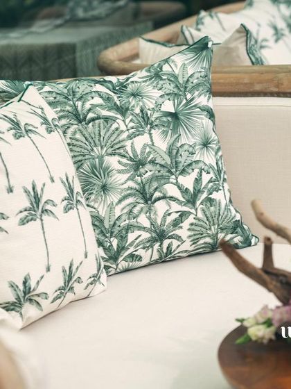 Custom cushions with a palm tree print, adding to the botanical theme of the 'Garden of Gaia' baby shower.