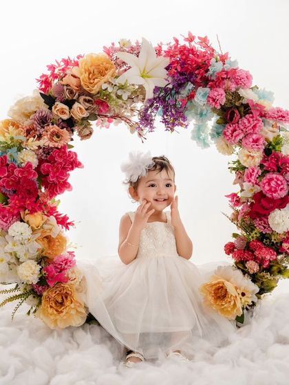 The purest form of joy and innocence is captured in this little angel's smile as she sits in our floral wreath.