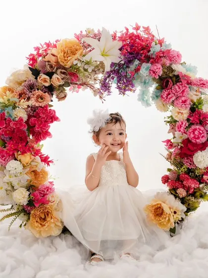 The purest form of joy and innocence is captured in this little angel's smile as she sits in our floral wreath.