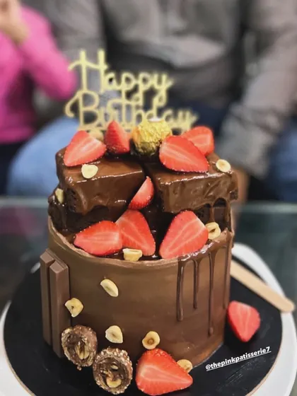 A chocolate overload cake, loaded with fresh strawberries, KitKats, Ferrero Rocher, and chocolate drip.
