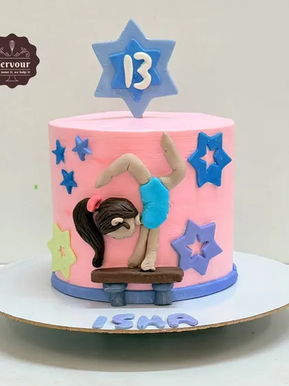 A gymnastics theme cake for a 13th birthday. This red velvet cake is decorated with a fondant gymnast on a balance beam, surrounded by colourful stars.