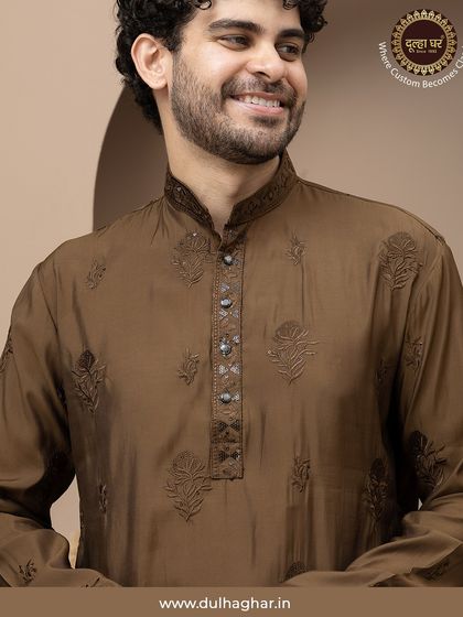 A close-up of the earthy brown kurta, highlighting the detailed embroidery on the placket and the rich texture of the fabric.