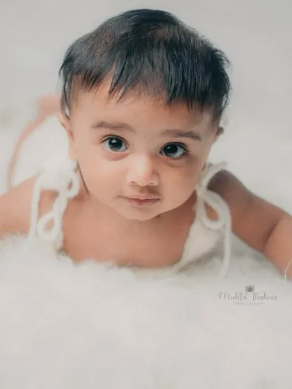 A perfect tummy time pose on a soft, cloud-like blanket. This is a classic shot for a 5-month milestone session.