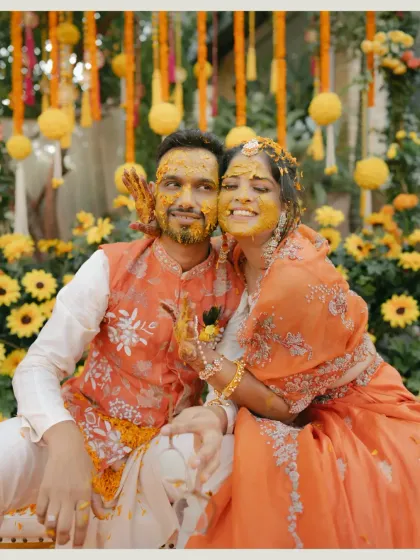 A happy portrait of the couple, smeared with turmeric and surrounded by marigolds, perfectly encapsulating the spirit of the Haldi.