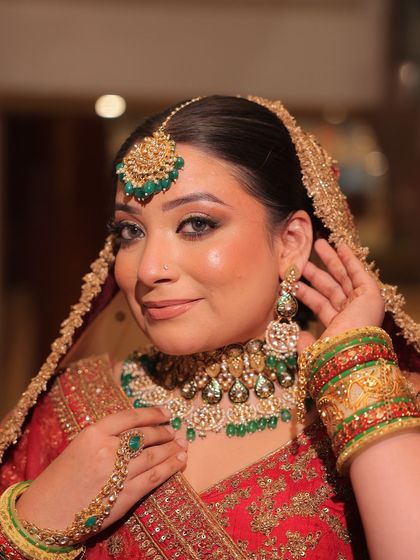 A full bridal look featuring a red lehenga with green-accented kundan jewellery. These images show how you can create a perfectly coordinated and stunning bridal look through my rental service.