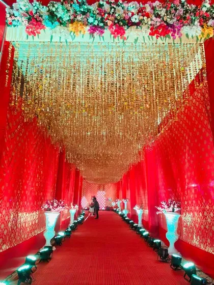A grand entrance featuring a ceiling completely covered in hanging golden strings, creating a shimmering, luxurious effect.