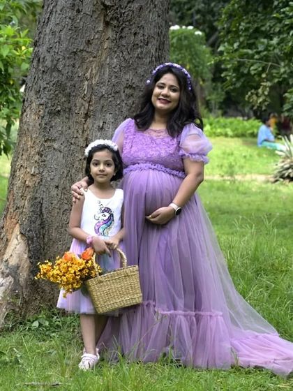 Another adorable mother-daughter moment. The lavender maternity gown pairs beautifully with the daughter's unicorn dress for a whimsical and sweet family photoshoot.