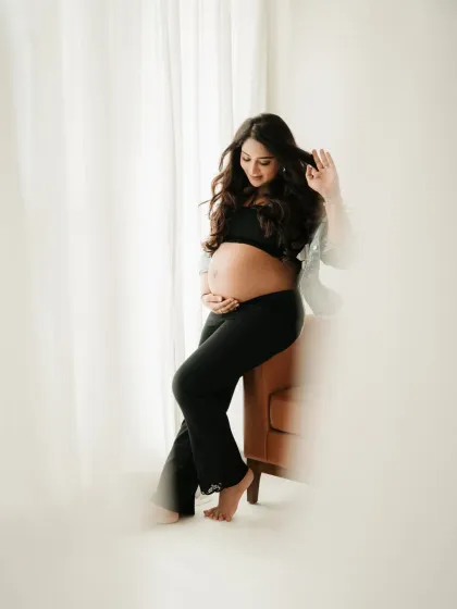 A stylish and relaxed solo portrait. A simple black outfit and soft window light are all that's needed to create a beautiful and modern maternity photo.
