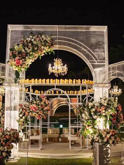 The mandap, lit for a magical night. The clean lines of the wire mesh structure, adorned with floral arrangements and crowned with candles, created a breathtaking focal point against the starry sky.