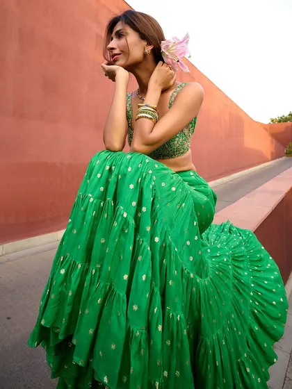 A vibrant green sharara with gold buti work. This piece from the Anam Cara collection is perfect for a mehendi or any daytime festive event.