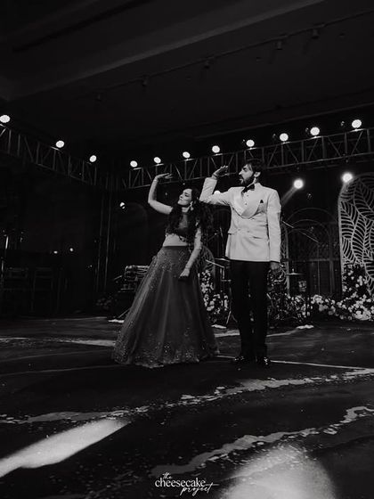 A dramatic, wide-angle black and white shot of the couple's dance performance on a vast stage.