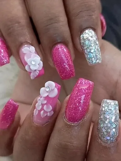 A close-up view of the pink glitter and 3D floral nail art, showing the texture and sparkle.