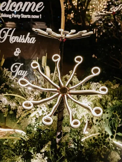 Another unique floral light installation, this one with a more star-like shape, adding a touch of modern artistry to the personalized welcome area.
