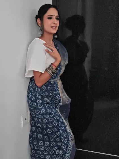 A full-length shot showing how the simple bun hairstyle works beautifully with the traditional saree and accessories.