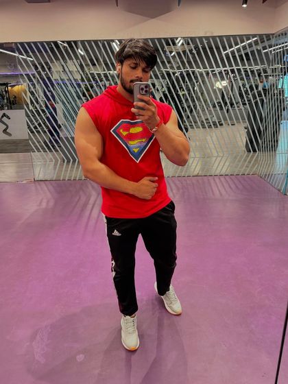 A front-facing pose showing chest and arm definition.