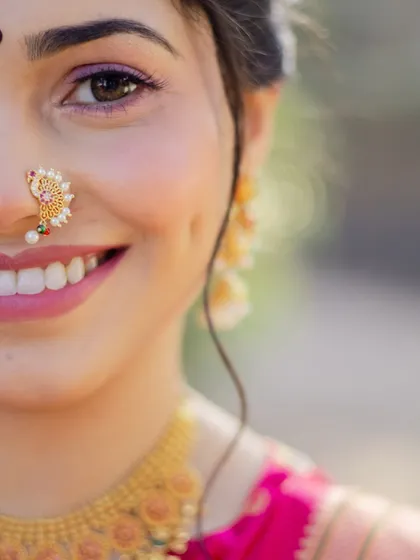 The joy on a bride's face is everything. This close-up captures the essence of a traditional Maharashtrian look, with a delicate Chandrakor bindi, a classic Nath, and makeup that enhances her natural radiance.