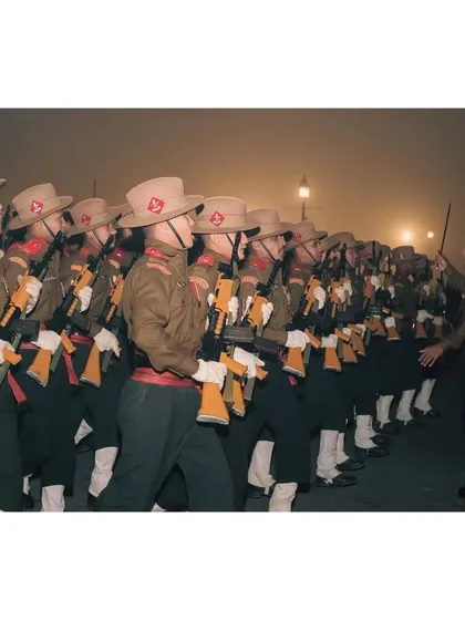 The Assam Rifles contingent marches in the early morning fog, their commander leading with a sword.