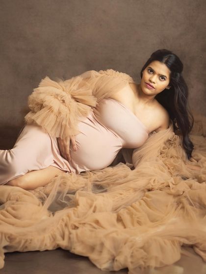 This reclining pose, surrounded by layers of soft tulle, creates a dreamy and artistic portrait. It’s a beautiful way to showcase the bump in a comfortable and elegant setting.