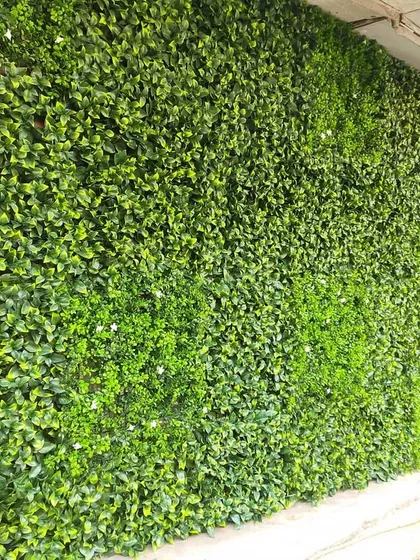 A dense and uniform artificial green wall, perfect for creating a simple, clean, and vibrant green backdrop. This type of installation offers immediate and lasting visual impact.