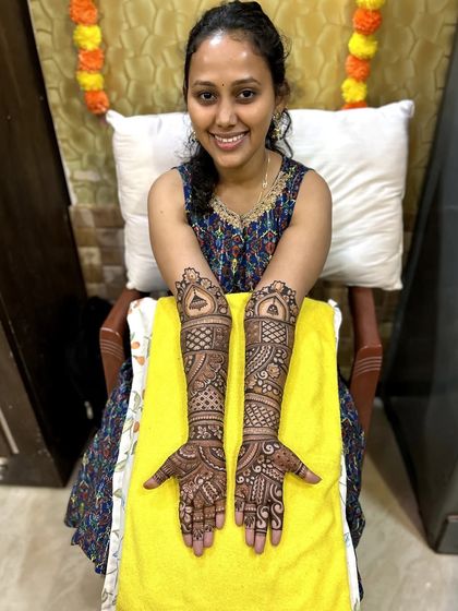 A smiling bride with her elegant and traditional wedding mehndi.