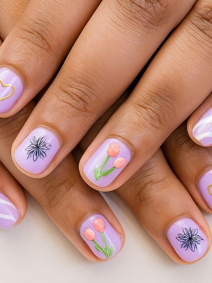 Pastels on natural nails. This dreamy lilac set features a mix of hand-painted florals, gold hearts, and subtle stripes, perfect for a soft and romantic look.