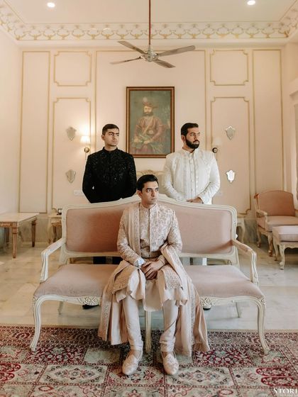 A regal portrait of the groom, Shubham, seated, flanked by his groomsmen, exuding an aura of classic royalty.