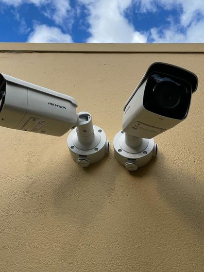 Two Hikvision bullet cameras installed on an exterior wall to cover multiple angles. This approach eliminates blind spots and provides overlapping fields of view for comprehensive security.