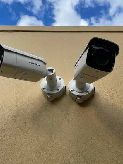 Two Hikvision bullet cameras mounted against a wall, angled to provide wide coverage of an outdoor area. This setup is perfect for monitoring parking lots or the sides of a building.