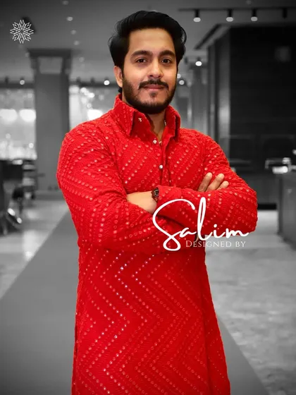 A client wearing a bright red kurta with a textured, geometric pattern. This bold and confident look is perfect for making an impression at any celebration.