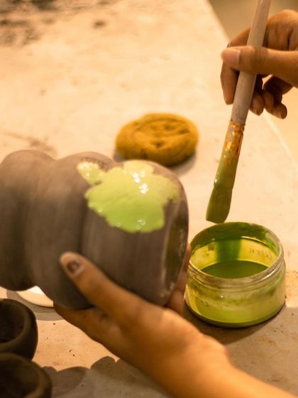 The second step of Mishima: applying a vibrant green slip into the carved designs. This color will remain after the excess is wiped away.