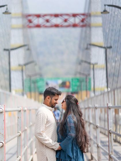A close-up of the couple on the Janki Setu bridge, sharing a loving gaze. The symmetrical lines of the bridge create a strong and visually interesting composition.