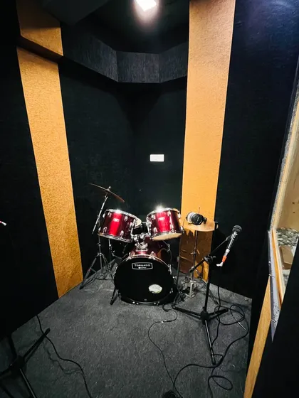 Our acoustically treated drum room is ready for you to lay down some beats. It's equipped with a full drum kit and microphones, ideal for both practice sessions and professional drum track recording.