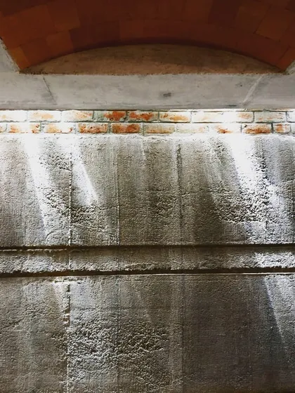 Even a basement can be delightful. I used a jack arch roof system and high-level openings to bring slivers of natural light into this basement, creating bright patterns on the textured concrete wall.