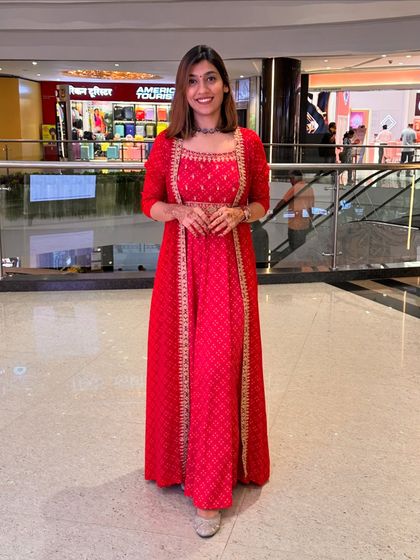 A full-length shot of the red festive outfit, showcasing its flow and elegance.