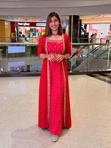 A full-length shot of the red festive outfit, showcasing its flow and elegance.
