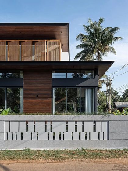 The facade combines warm wood cladding with a perforated concrete block wall, creating a rich material palette.